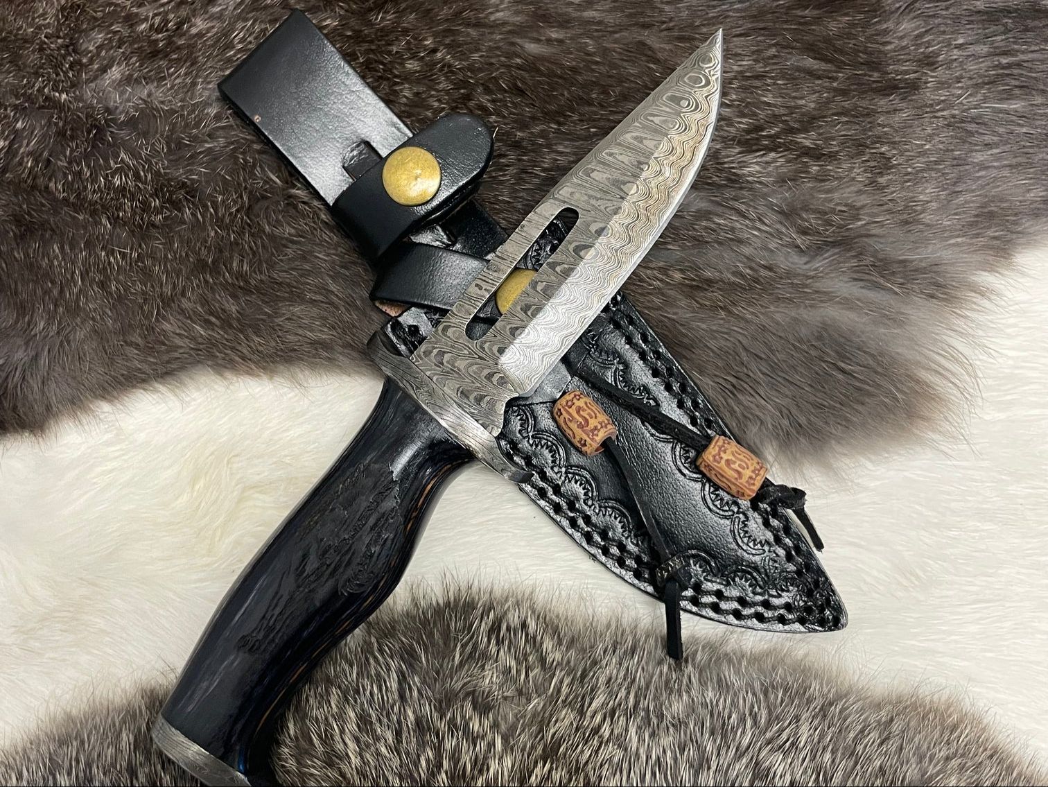 Lunar Guardian hunting knife with Damascus steel blade and engraved handle, displayed in a black leather sheath.